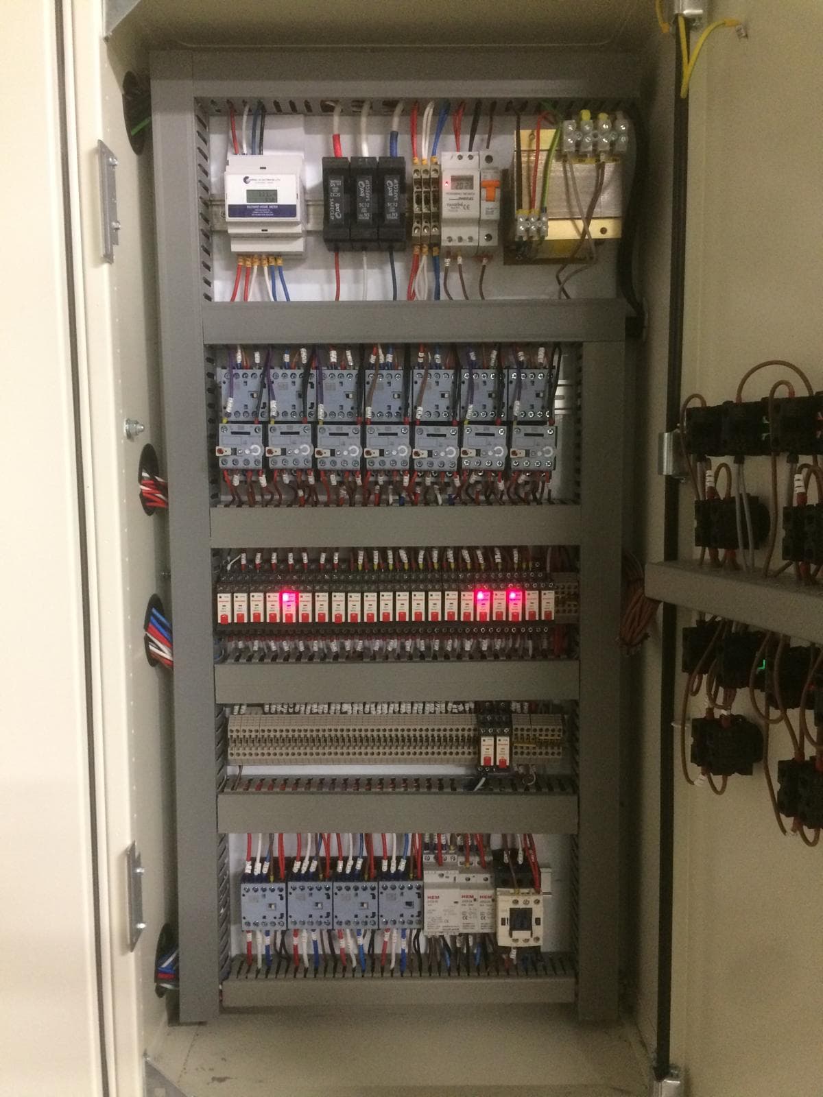 Open electrical control cabinet with organized switchgear and wiring