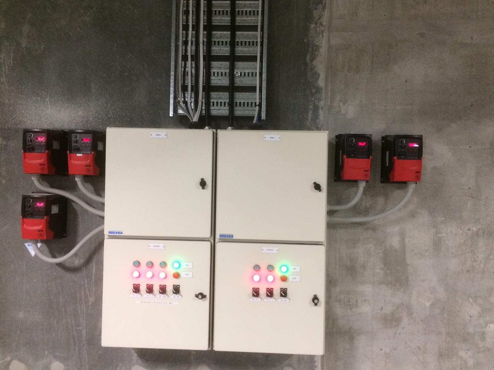 Pump control panels installed on a wall with illuminated status indicators